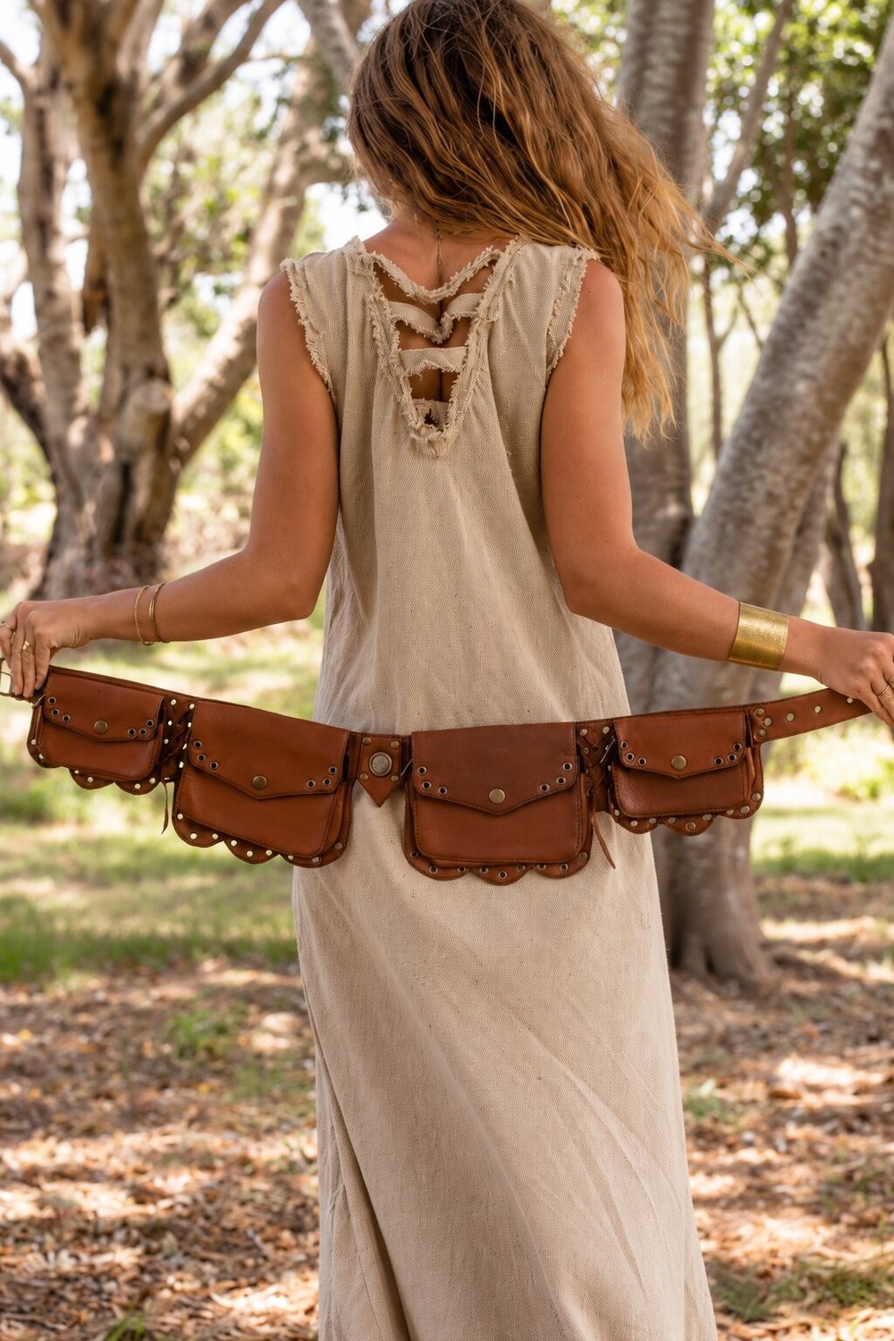 Brown leather pocket belt with multiple brass-studded flap pockets and a central buckle