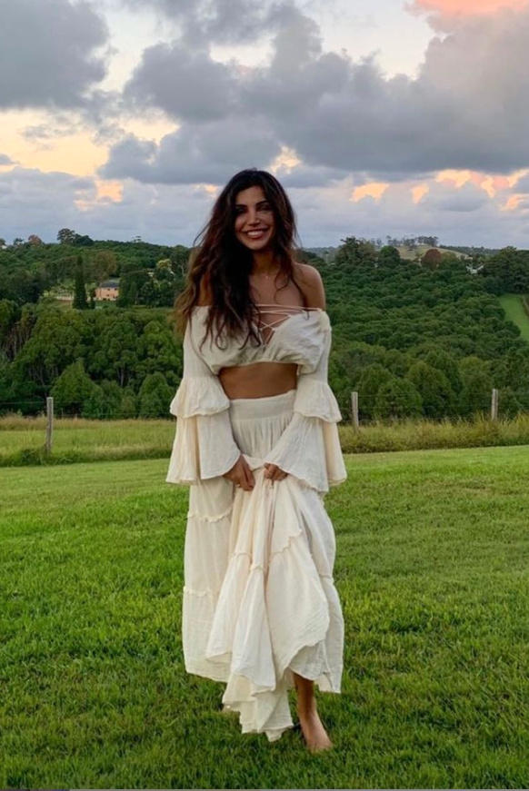 White off-shoulder cropped top with ruffled bell sleeves and tied neckline